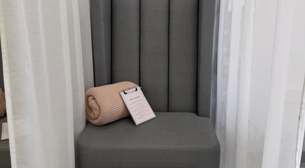 Relaxing seating area at Aurae London - Nail Artistry & Beauty, Romford, England, GB with comfy throw and clipboard.