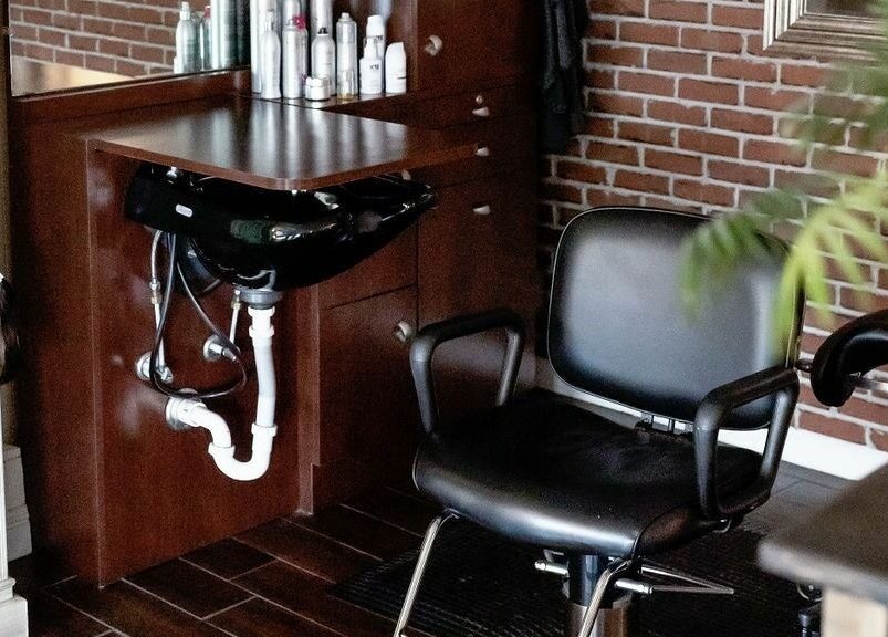 Modern hair station at Hair Loft on Linden, Pinehurst, North Carolina, US, with chair and mirror.