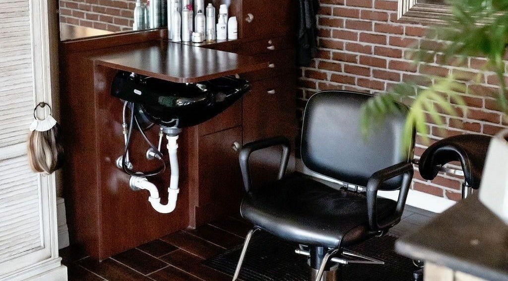 Modern hair station at Hair Loft on Linden, Pinehurst, North Carolina, US, with chair and mirror.