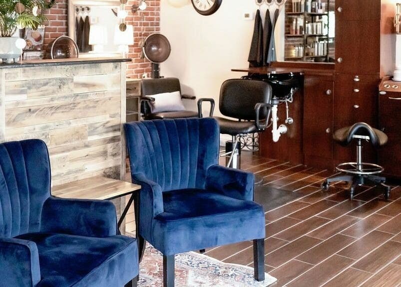 Elegant waiting area at Hair Loft on Linden in Pinehurst, North Carolina, US with blue chairs and stylish decor.