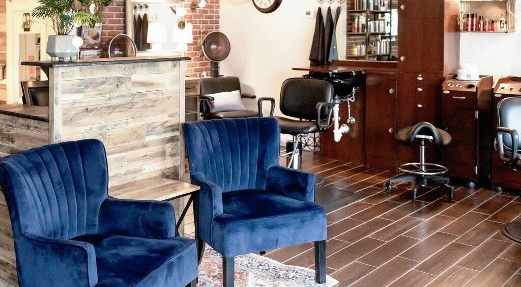 Elegant waiting area at Hair Loft on Linden in Pinehurst, North Carolina, US with blue chairs and stylish decor.