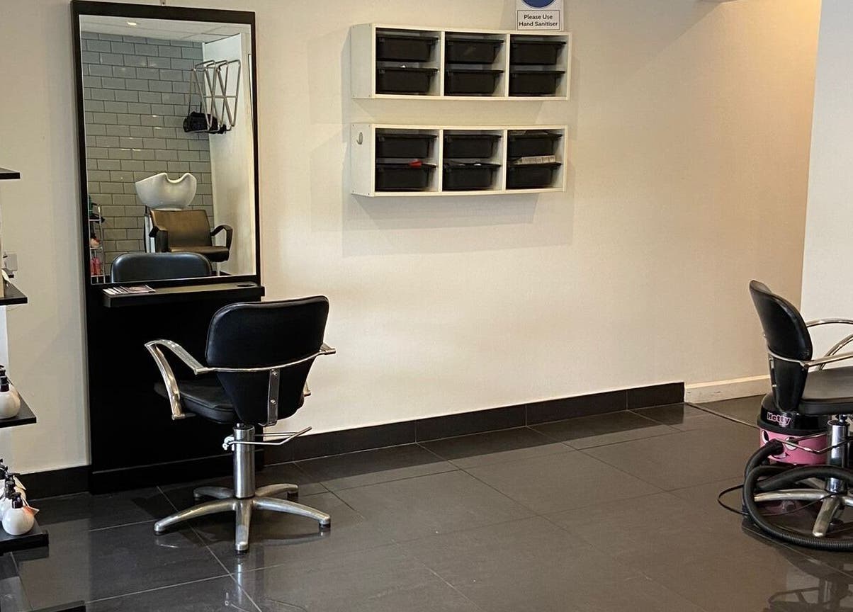 Modern salon interior at Capellis Birmingham Ltd, Birmingham, England, GB featuring sleek chairs and products.
