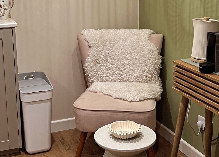Comfortable seating area at Salon Megan’s, Surrey, England, GB. Features soft chair, table, and decor.