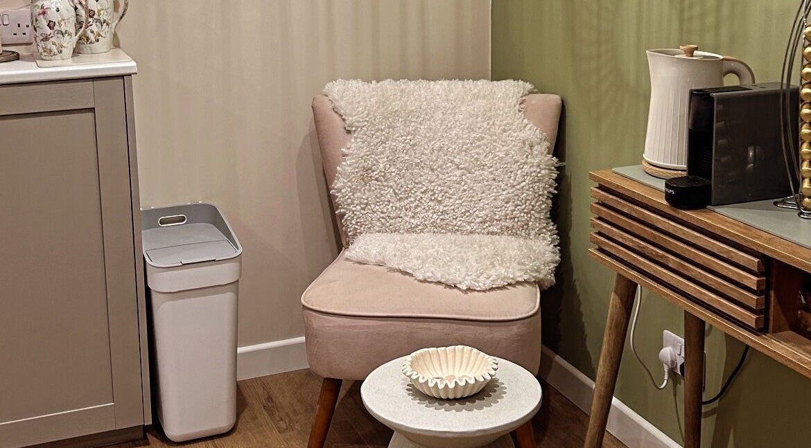 Comfortable seating area at Salon Megan’s, Surrey, England, GB. Features soft chair, table, and decor.