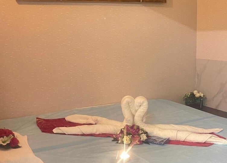 Relaxing massage room at Body Sky Massage & Spa JLT - Cluster W, Dubai, AE, with swan towel art and flowers.