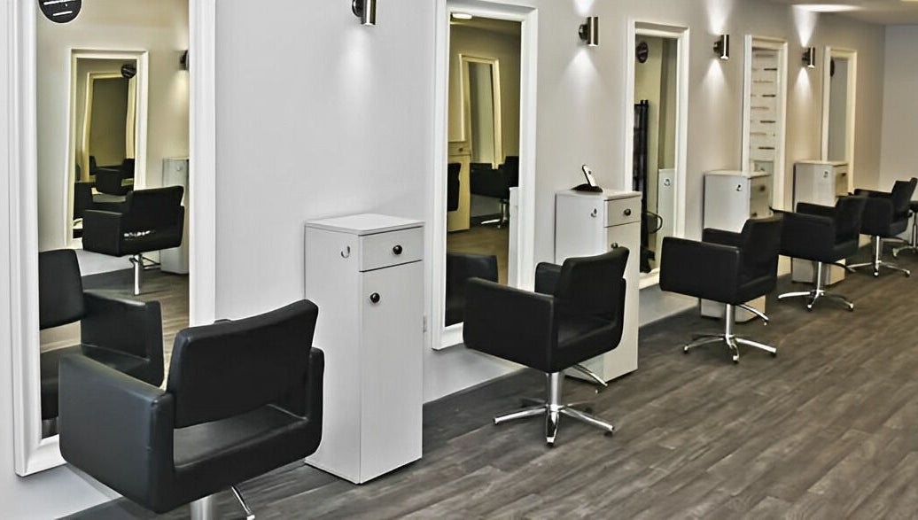 Sleek salon chairs and mirrors at Innovation, Saint Helens, England, GB. Modern design for a relaxing experience.