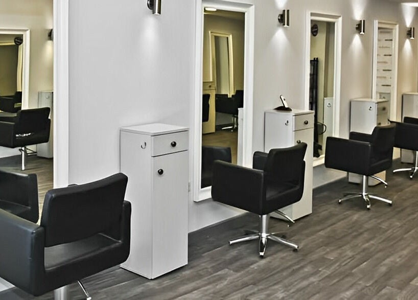 Sleek salon chairs and mirrors at Innovation, Saint Helens, England, GB. Modern design for a relaxing experience.