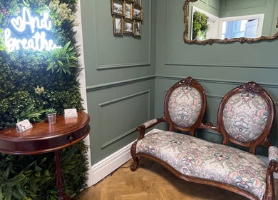 Elegant vintage seating and greenery wall at Rejuvenate Massage Therapy, Larne, Northern Ireland, GB.