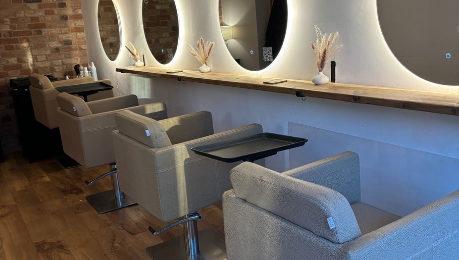 Chic hair styling stations at Alice Olivia Hair, Alcester, England, GB with modern mirrors and cozy chairs.