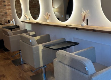 Chic hair styling stations at Alice Olivia Hair, Alcester, England, GB with modern mirrors and cozy chairs.