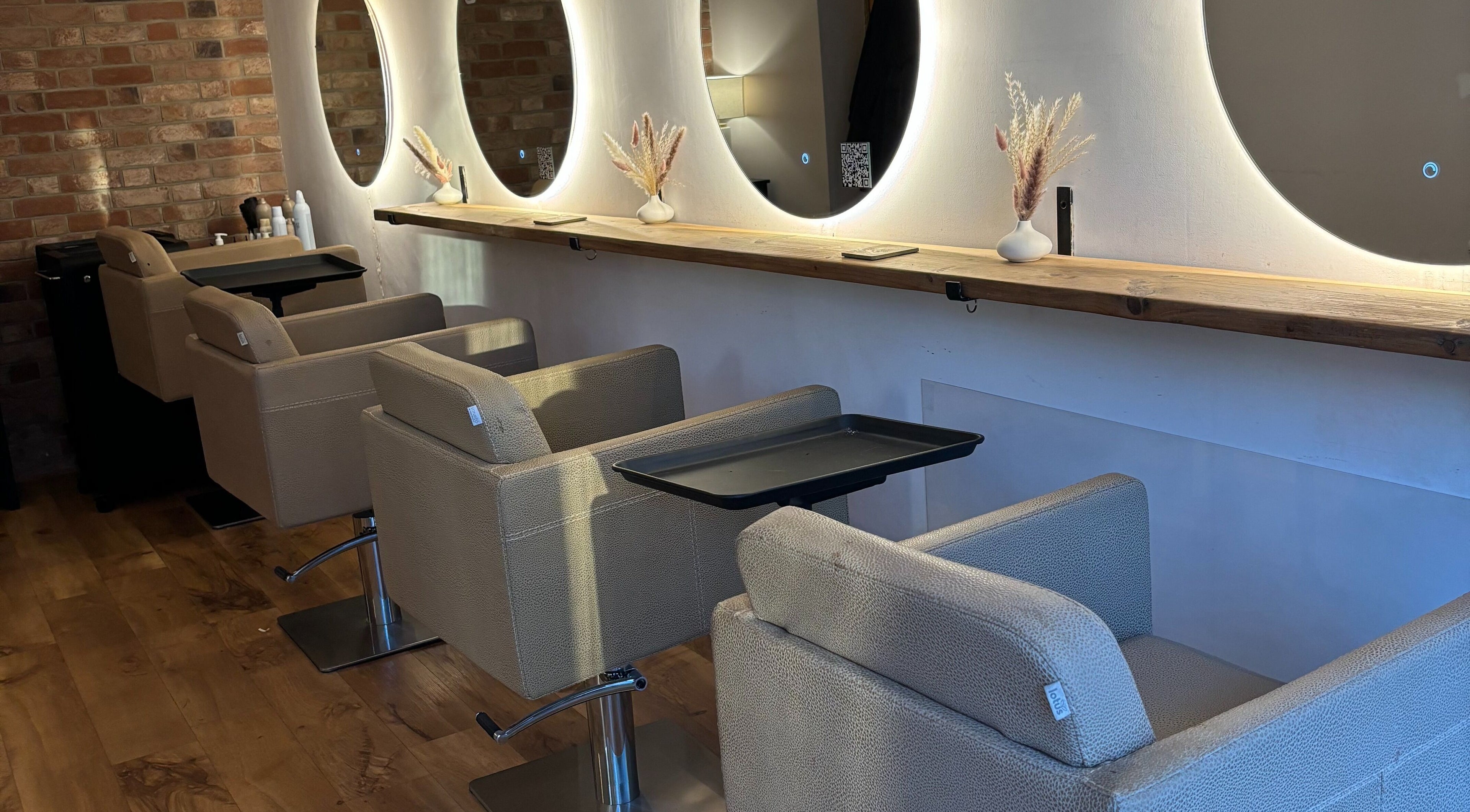 Chic hair styling stations at Alice Olivia Hair, Alcester, England, GB with modern mirrors and cozy chairs.