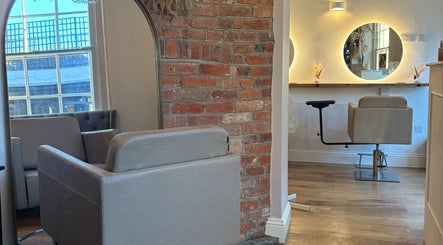 Stylish seating area inside Alice Olivia Hair, Alcester, England, GB, featuring modern decor and soft lighting.