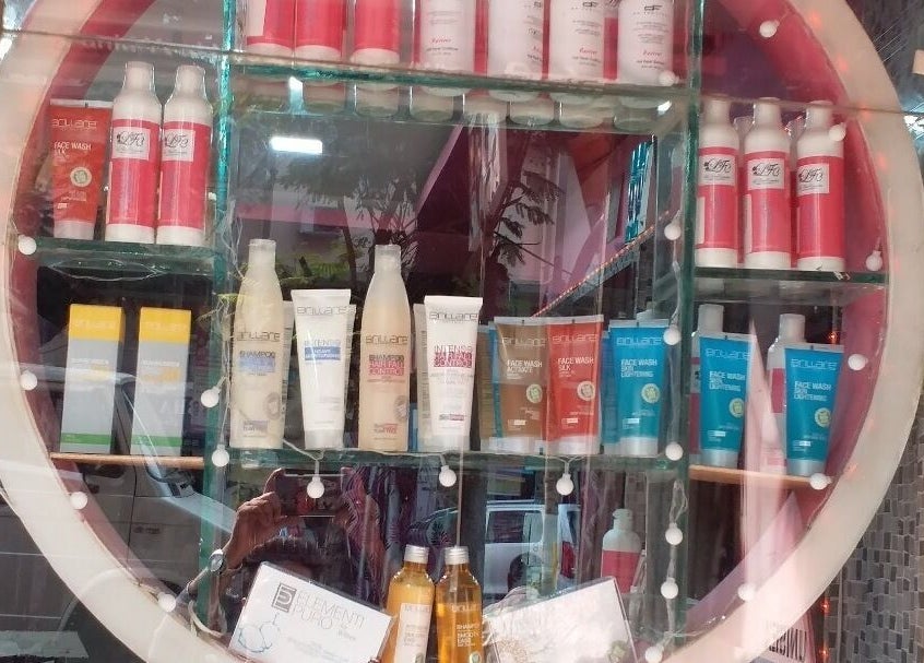 Milon Salon window showcasing beauty products in Mumbai, Maharashtra, IN.