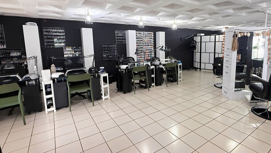 Interior moderno de D’Verzanni Salón en Guaynabo, Guaynabo, PR, mostrando estaciones de belleza y diseño chic.