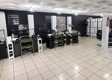 Interior moderno de D’Verzanni Salón en Guaynabo, Guaynabo, PR, mostrando estaciones de belleza y diseño chic.