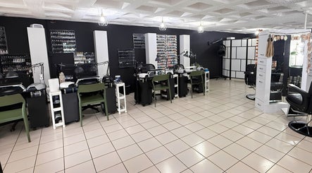 Interior moderno de D’Verzanni Salón en Guaynabo, Guaynabo, PR, mostrando estaciones de belleza y diseño chic.