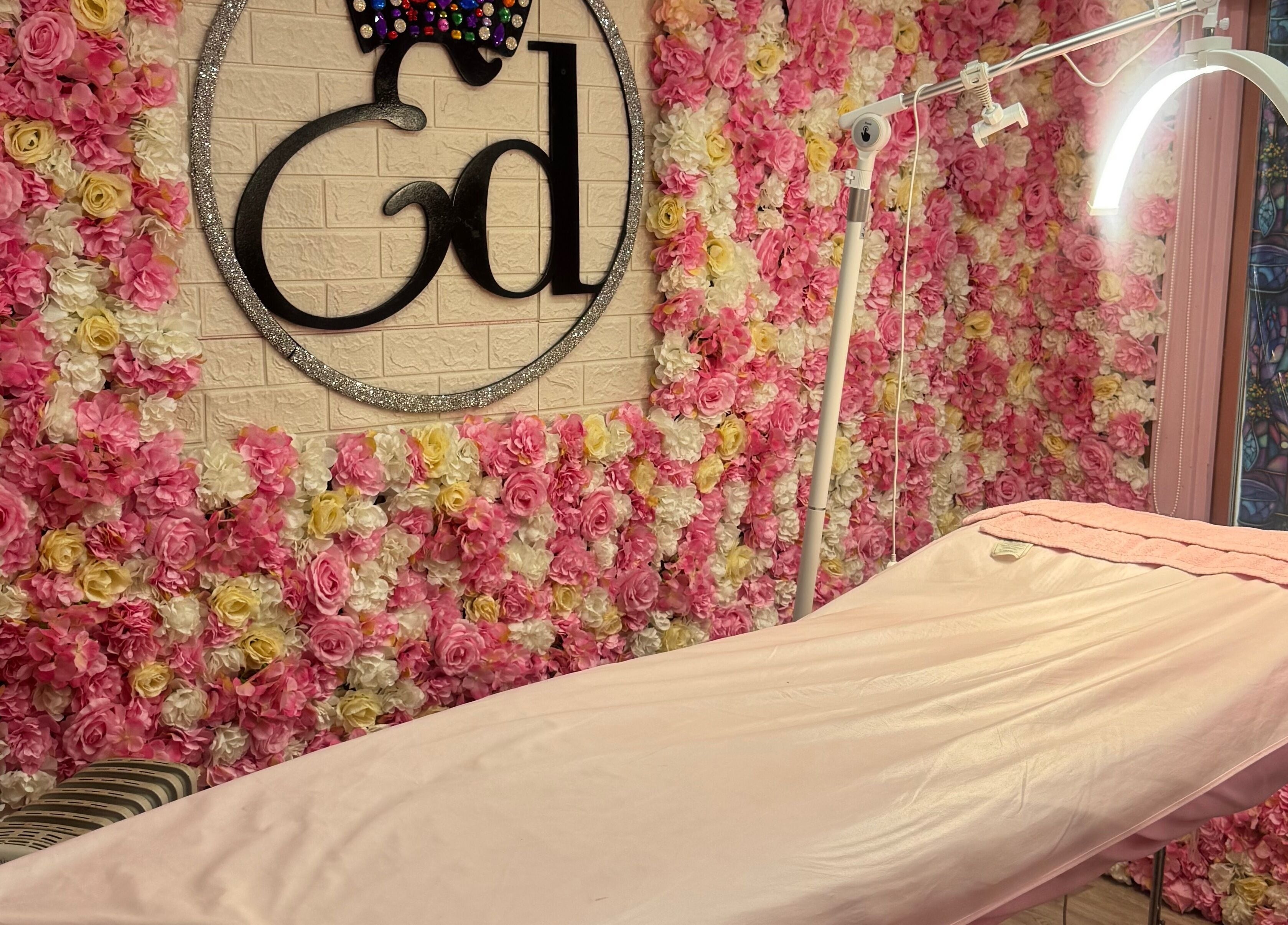 Luxurious treatment room at Elladoons Aesthetics, Smallford, England, GB, adorned with pink and white floral decor.