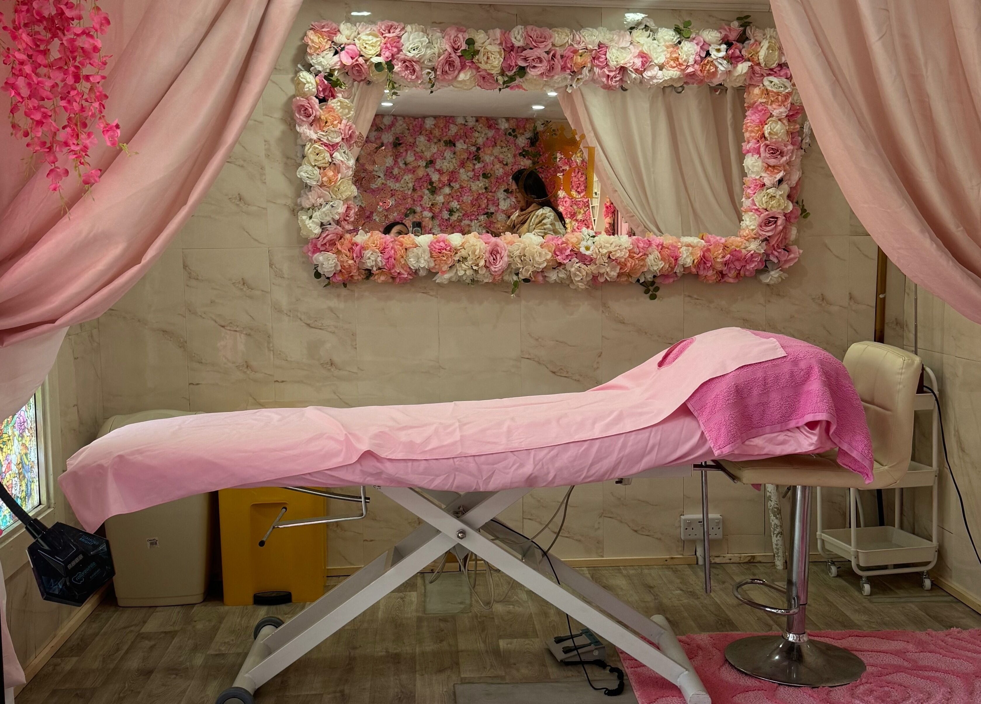 Luxurious treatment room at Elladoons Aesthetics, Smallford, England, GB, adorned with pink floral decor.