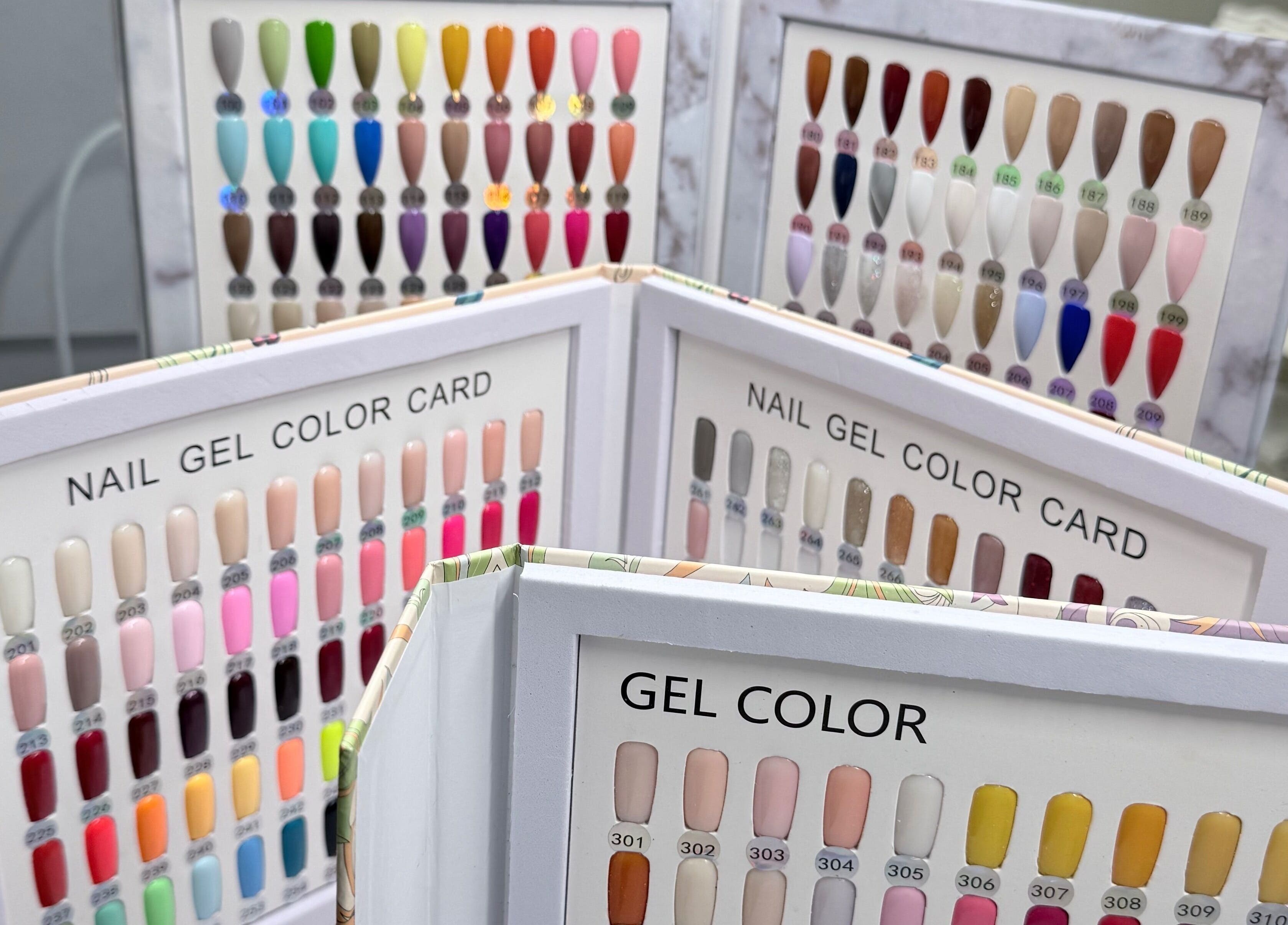 Colorful gel nail sample cards at Me Nail Spa, Alameda, California, US, showcasing various shades.