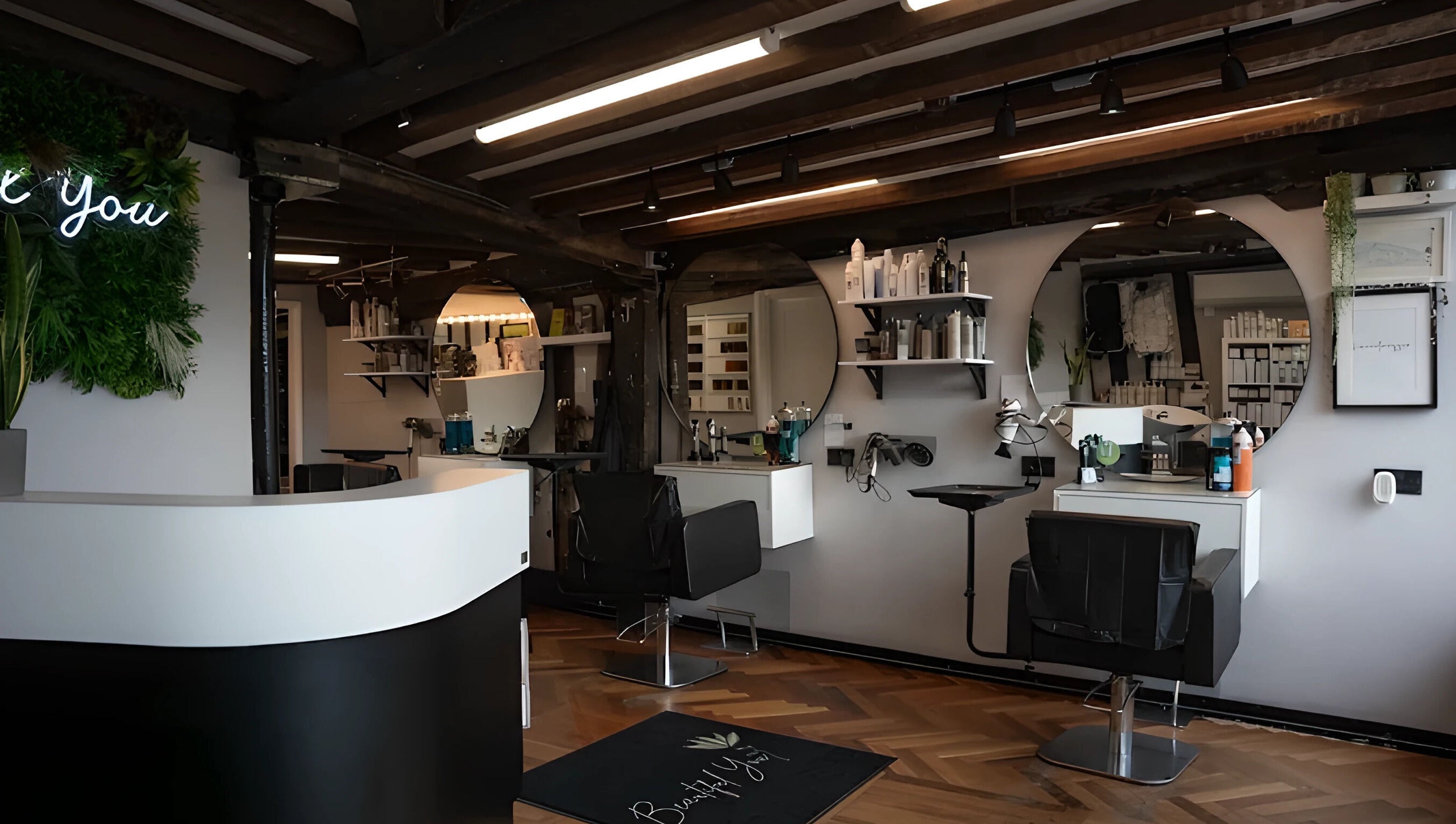 Modern salon interior at Beautiful You, Bures, England, GB, featuring sleek chairs and stylish decor.