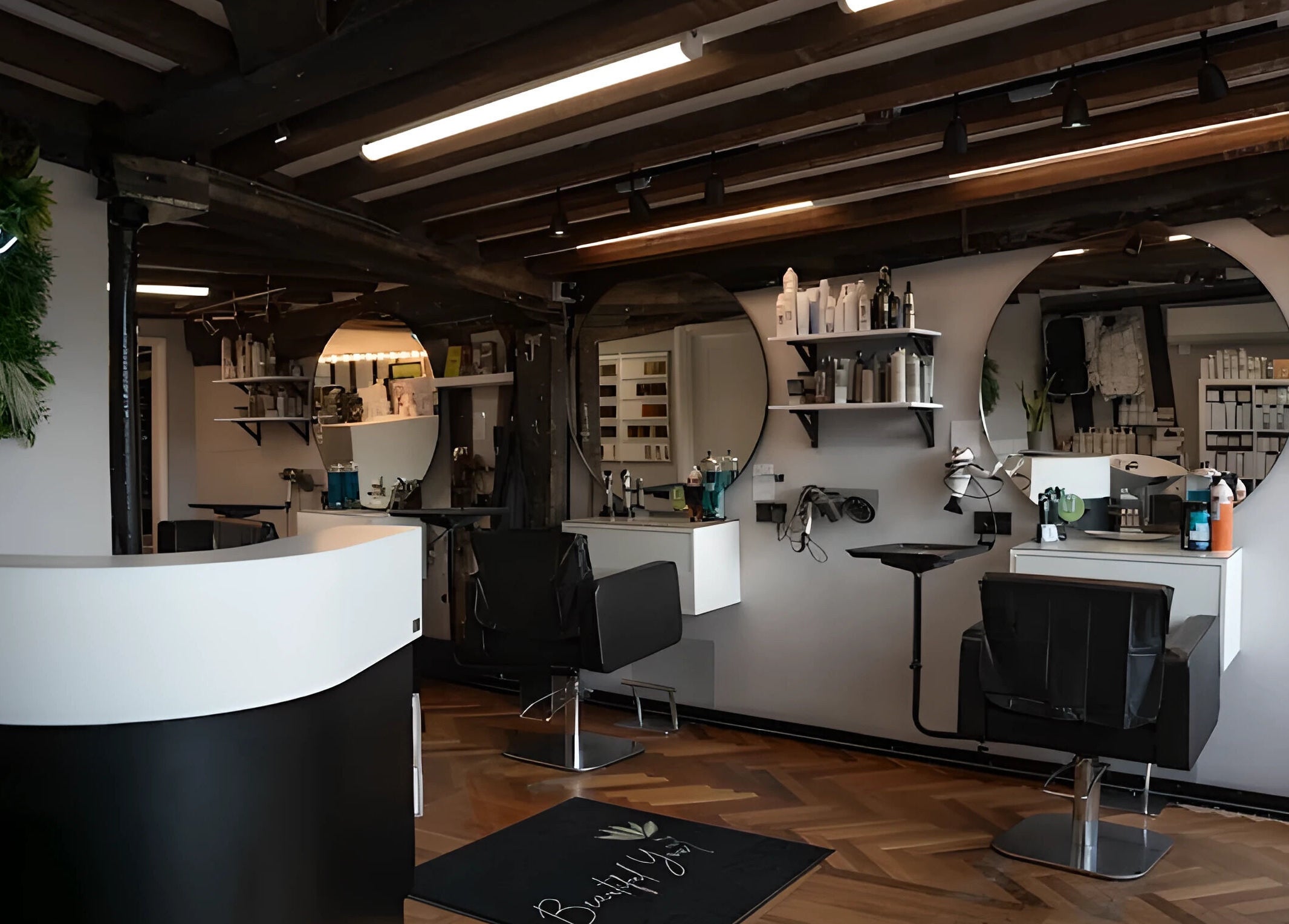 Modern salon interior at Beautiful You, Bures, England, GB, featuring sleek chairs and stylish decor.