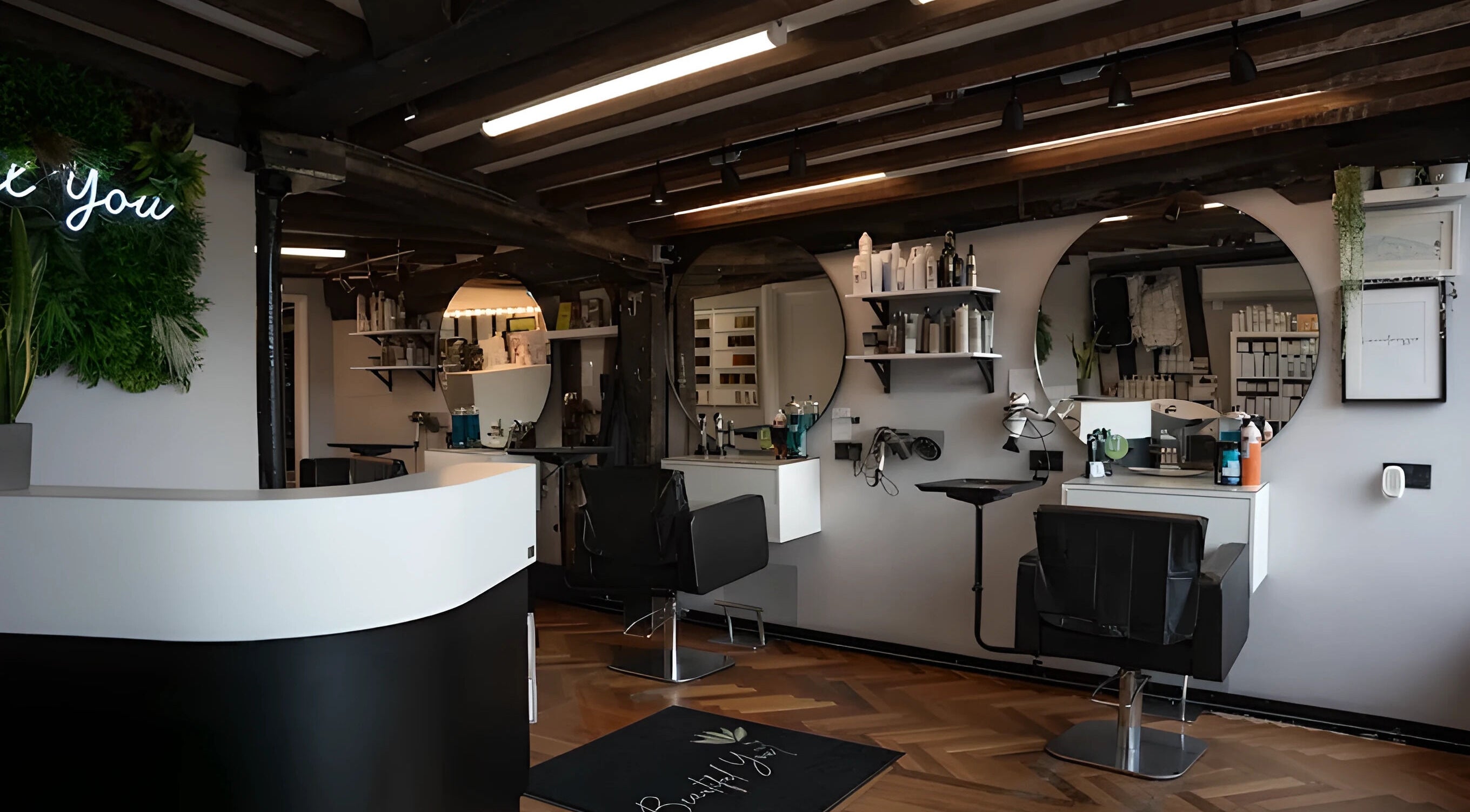 Modern salon interior at Beautiful You, Bures, England, GB, featuring sleek chairs and stylish decor.