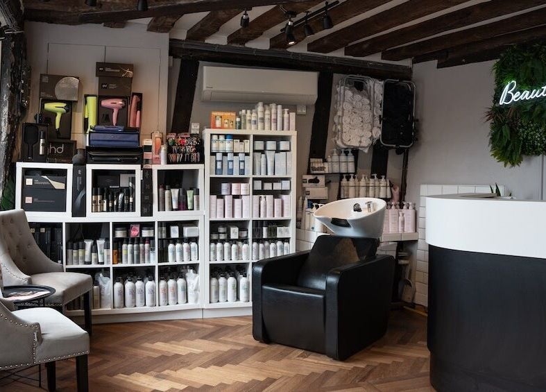 Interior of Beautiful You salon in Bures, England, GB with chic chairs and beauty products displayed.