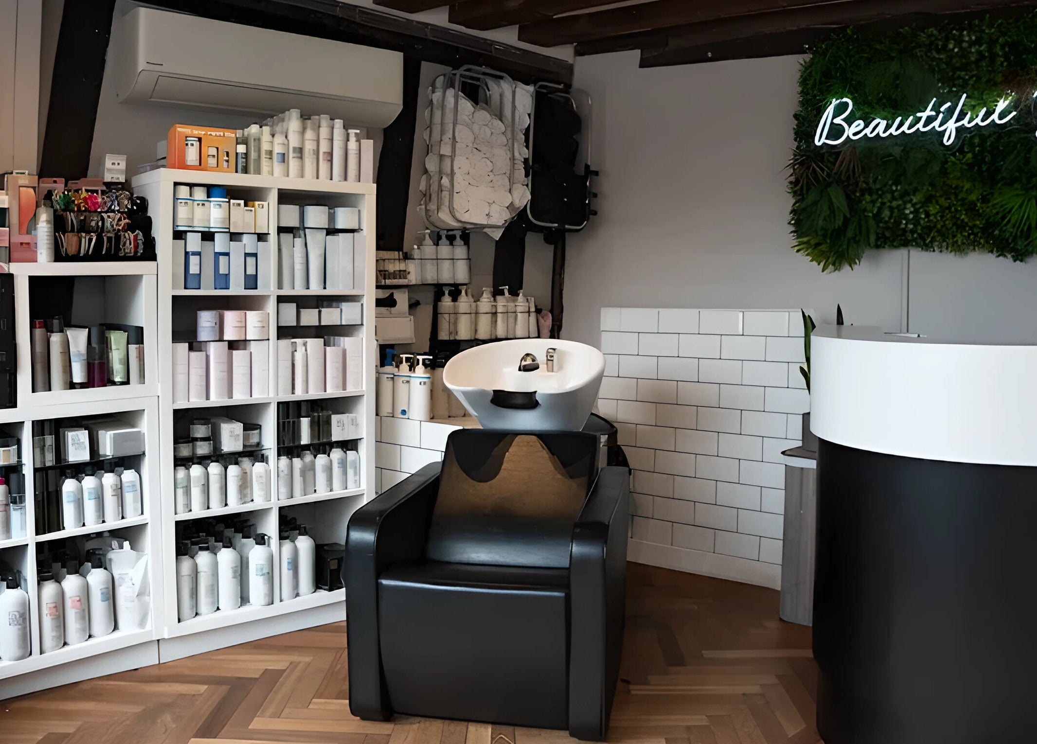 Modern salon interior at Beautiful You with hair products and chic furniture in Bures, England, GB.