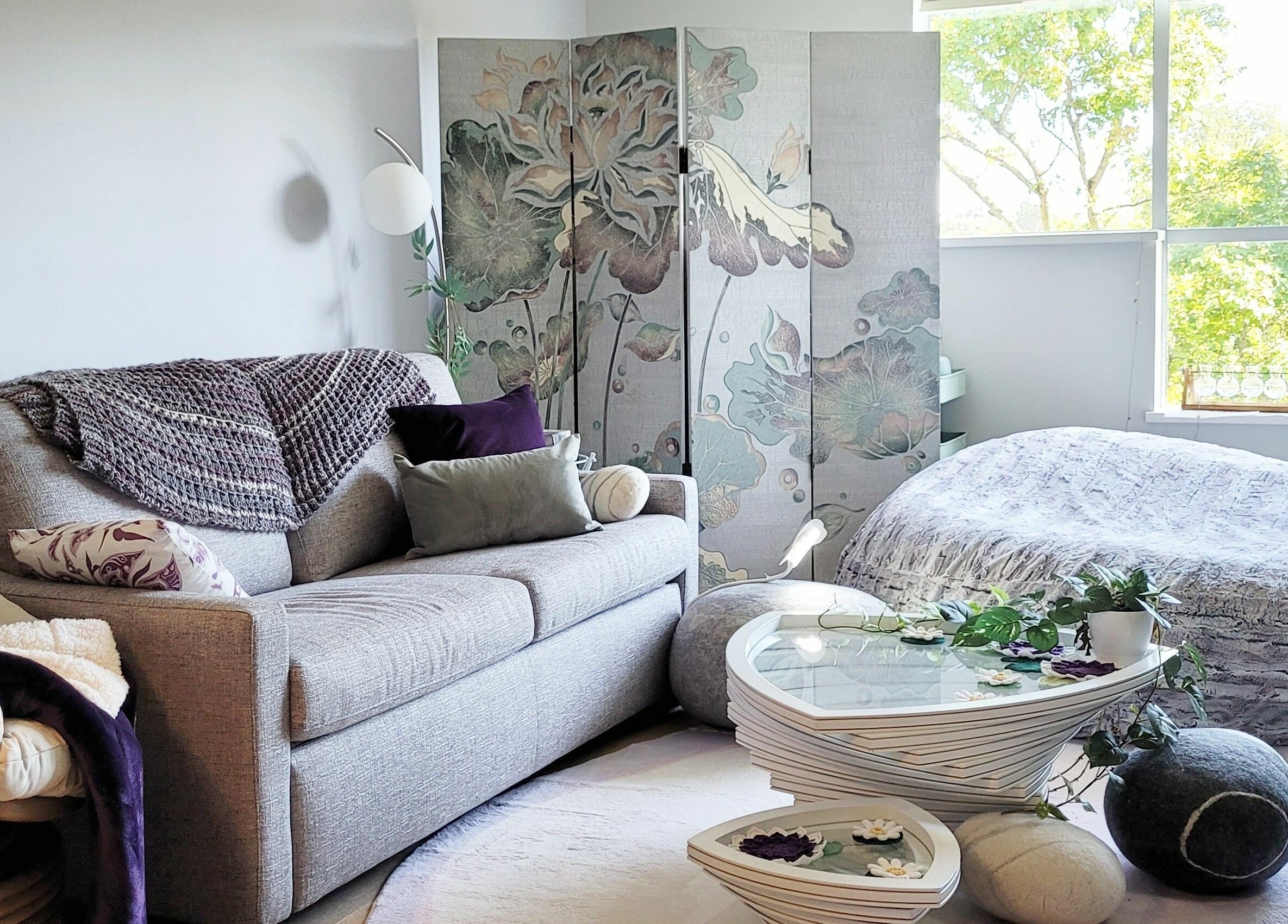Tranquil relaxation space at Ai-Lashes, Victoria, British Columbia, CA. Cozy couch, soft lighting, floral decor.