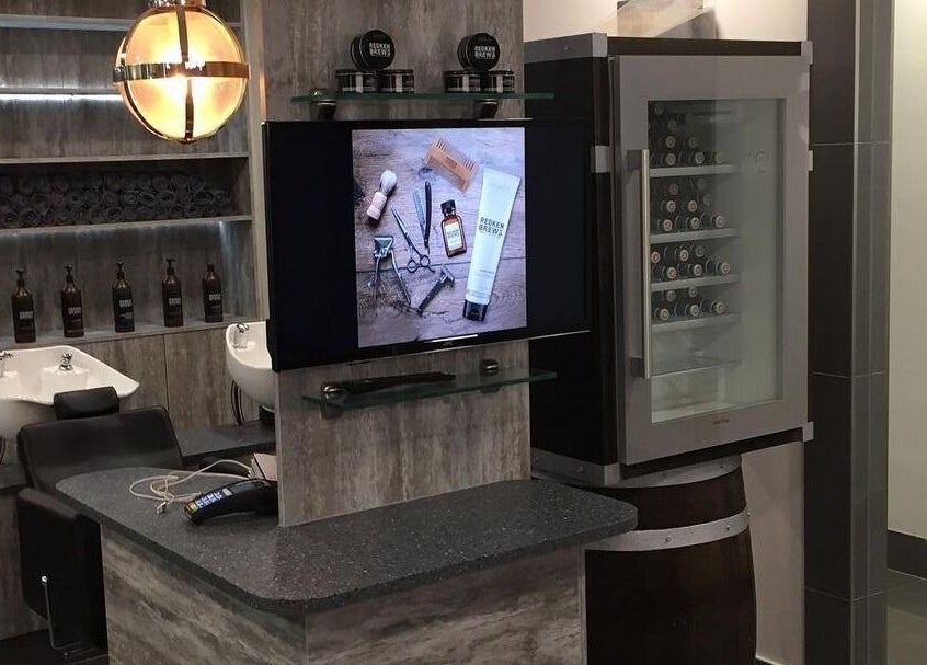 Modern interior of Chaps The Barbershop in Edinburgh, Scotland, GB showing washbasins and product display.
