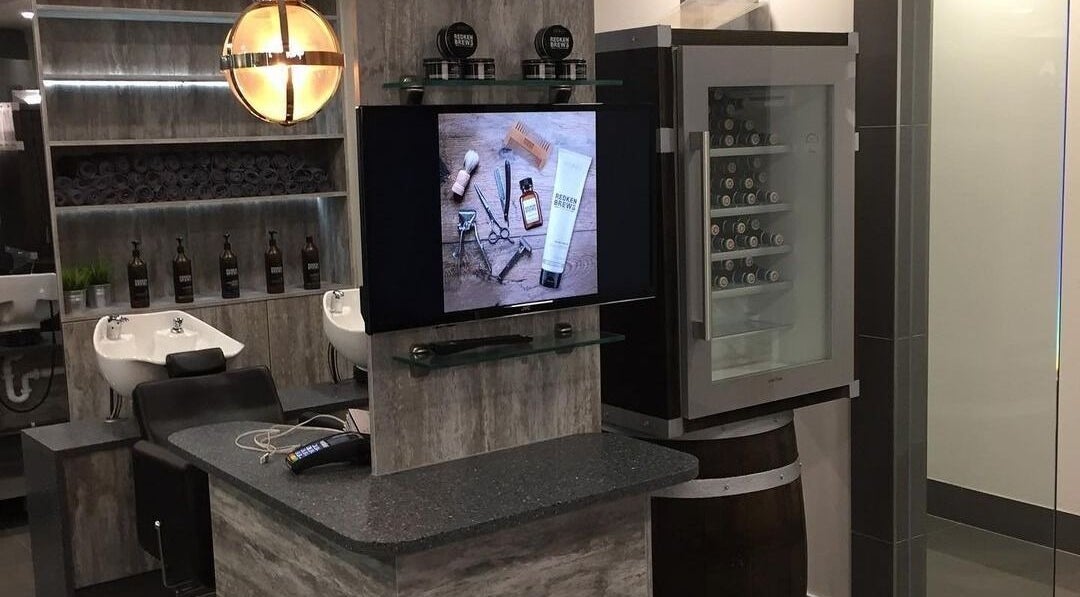 Modern interior of Chaps The Barbershop in Edinburgh, Scotland, GB showing washbasins and product display.