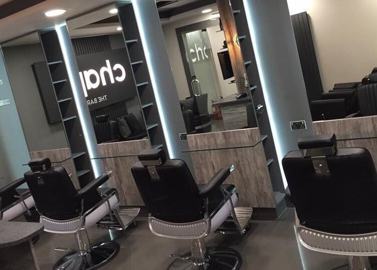 Inside Chaps The Barbershop in Edinburgh, Scotland, GB, featuring sleek black barber chairs and modern mirrors.