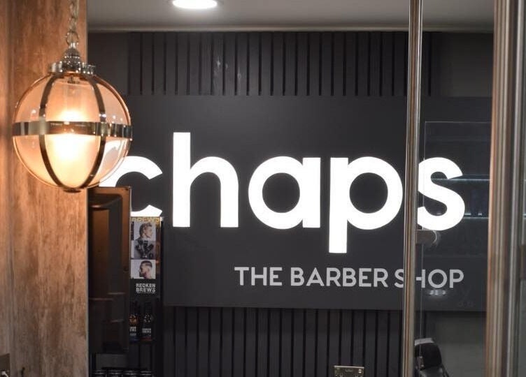 Interior view of Chaps The Barbershop sign with modern lighting in Edinburgh, Scotland, GB.