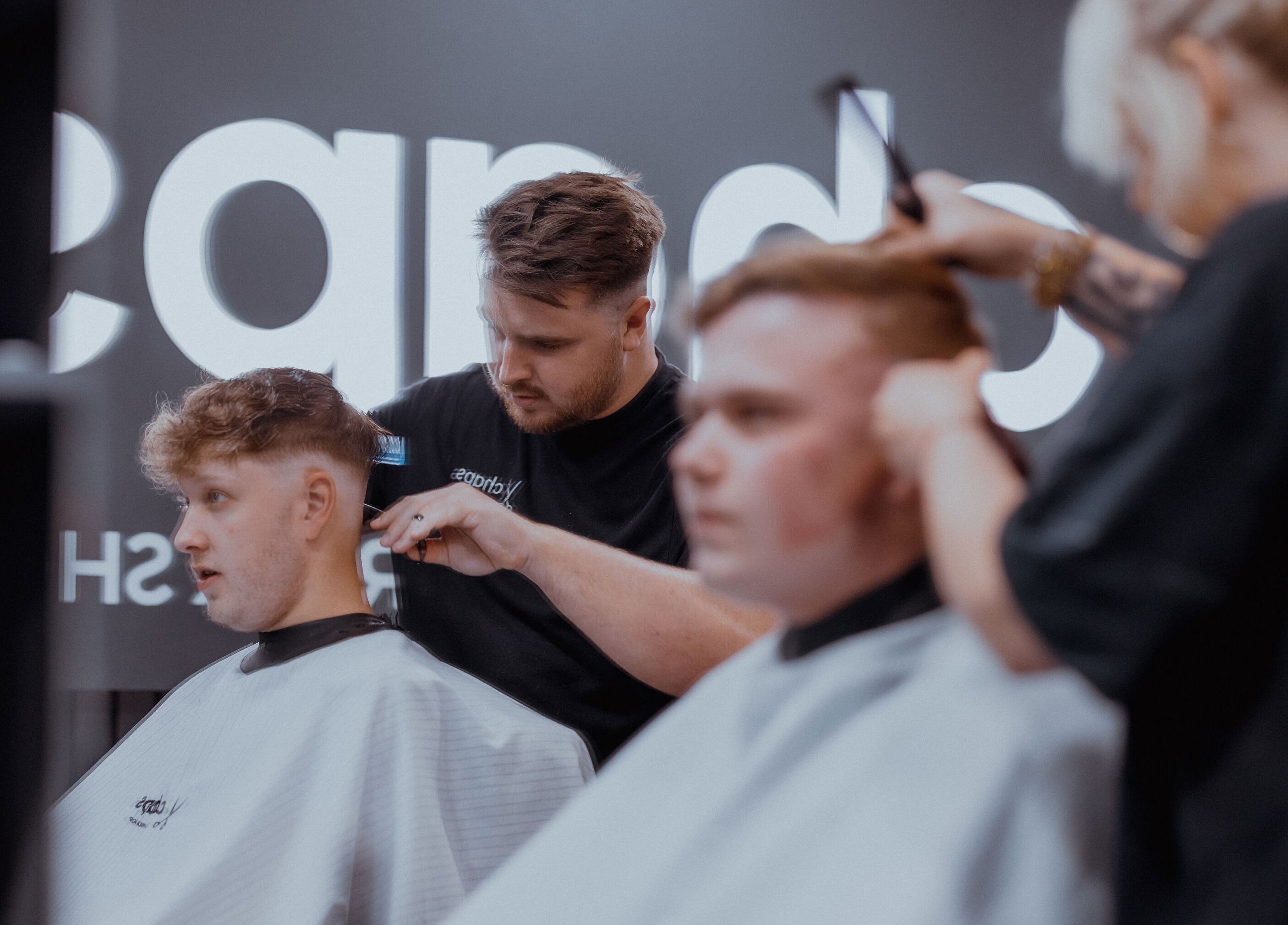 Barber crafting trendy hairstyle at Chaps The Barbershop, Edinburgh, Scotland, GB.