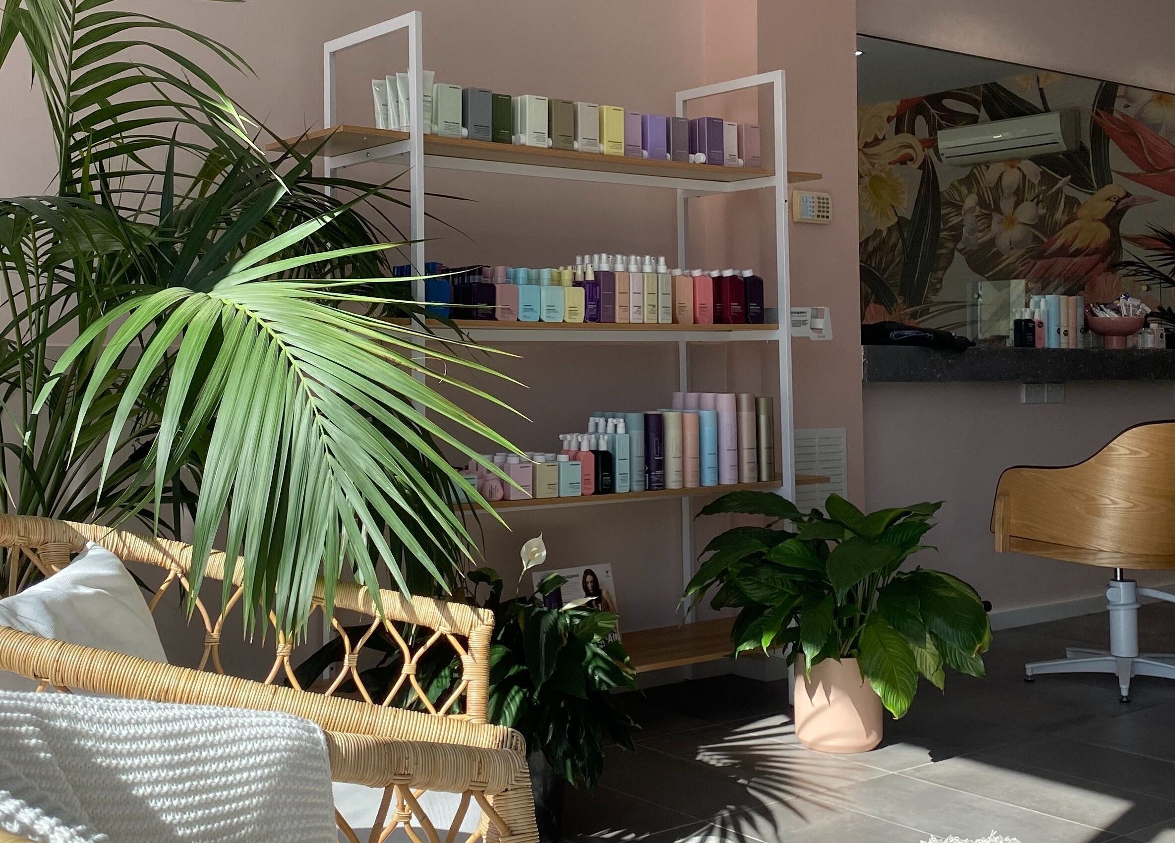 Inviting salon corner at Hair + Her, Gungahlin, Australian Capital Territory, AU with tropical plants and beauty products.