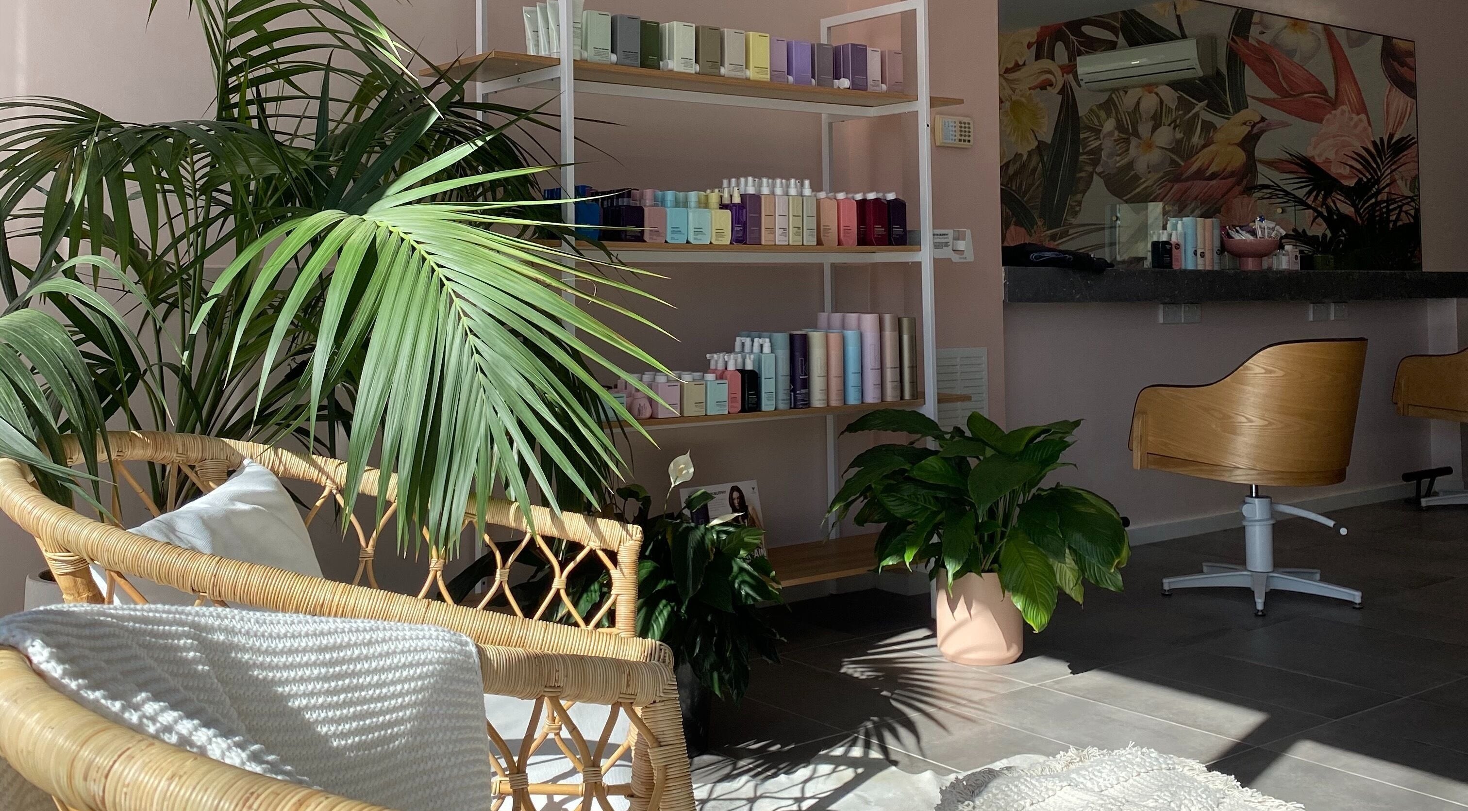 Relaxing interior of Hair + Her in Gungahlin, Australian Capital Territory, AU with lush plants and product display.