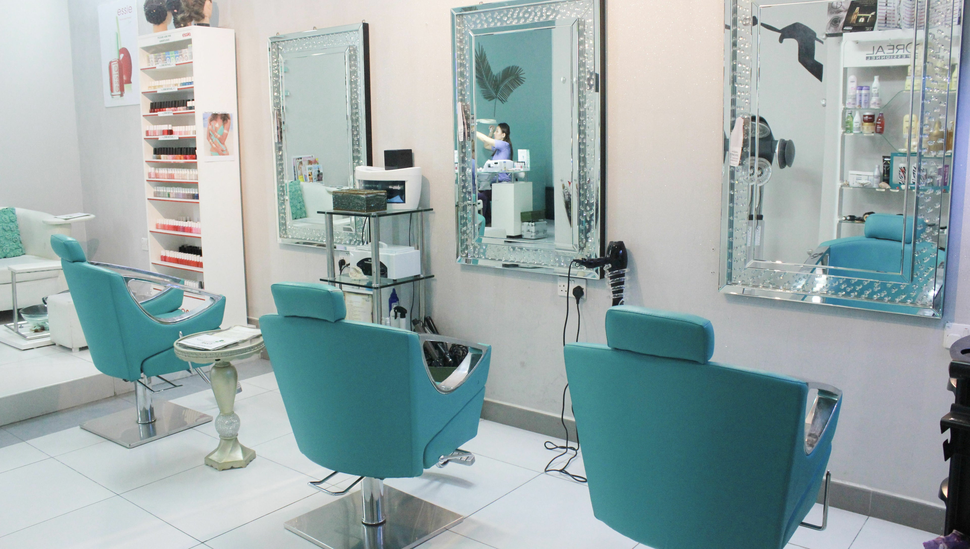 Elegant salon interior with turquoise chairs at Naturopathy Touch Cluster D, Dubai, AE.