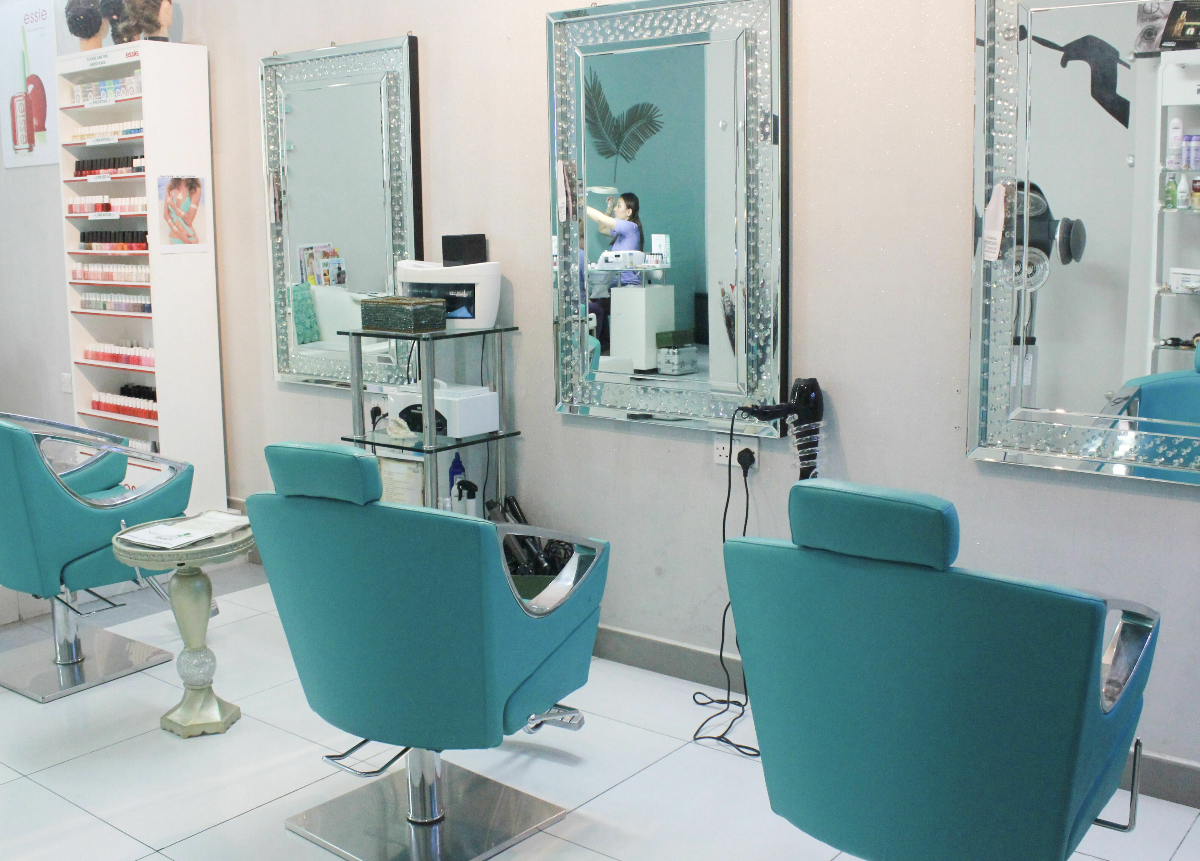 Elegant salon interior with turquoise chairs at Naturopathy Touch Cluster D, Dubai, AE.