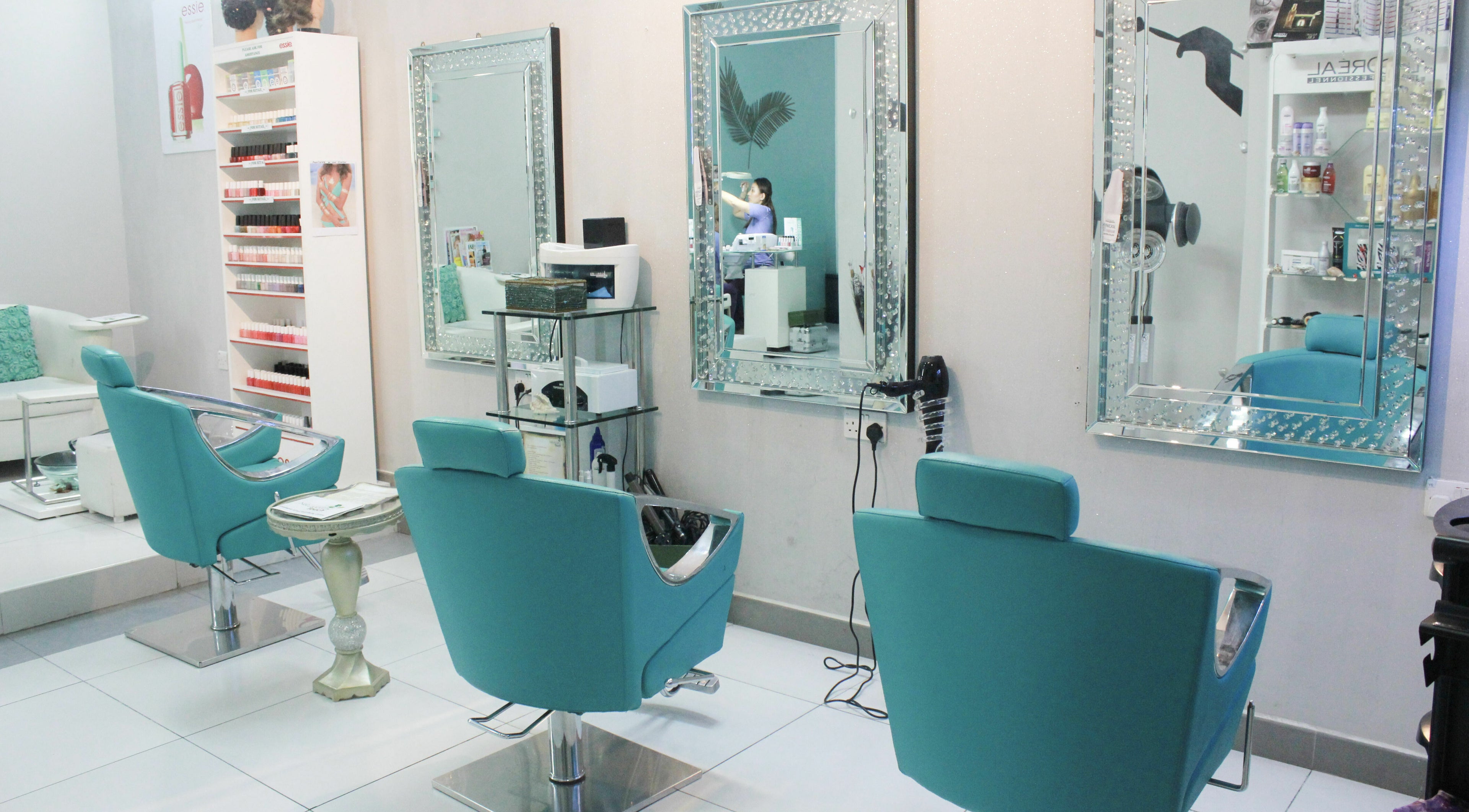 Elegant salon interior with turquoise chairs at Naturopathy Touch Cluster D, Dubai, AE.
