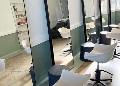 Chic salon interior at Katie Jones Hair in Windsor, Queensland, AU with modern mirrors and styling chairs.