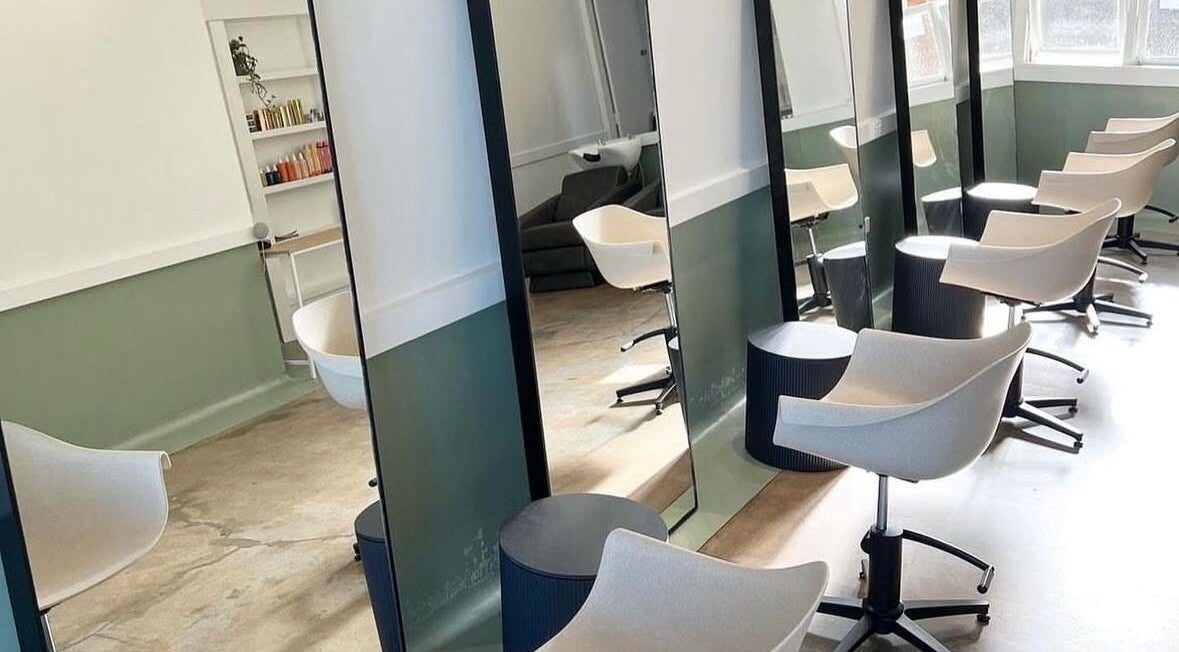 Chic salon interior at Katie Jones Hair in Windsor, Queensland, AU with modern mirrors and styling chairs.