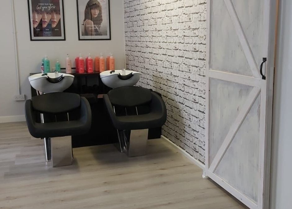 Modern washing area at Salon 10, Dalgety Bay, Scotland, GB, featuring stylish chairs and vibrant shampoo bottles.