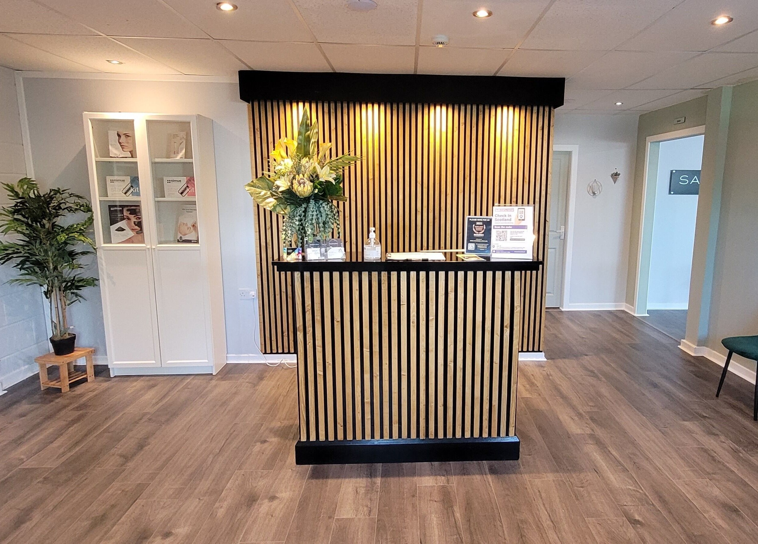 Reception area of Salon 10 in Dalgety Bay, Scotland, GB with modern decor and floral arrangement.