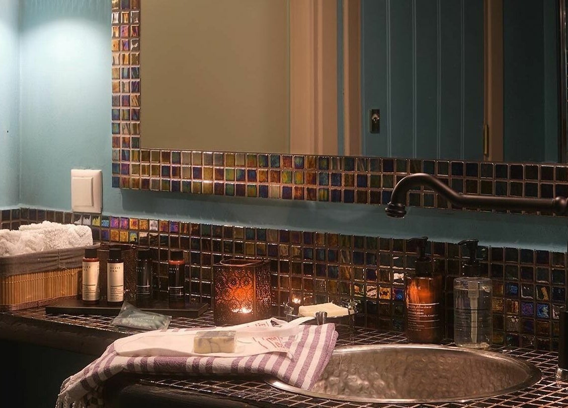 Elegant sink area at Eressian Hammam and Spa in Ερεσός, GR, with mosaic tiles and spa products.