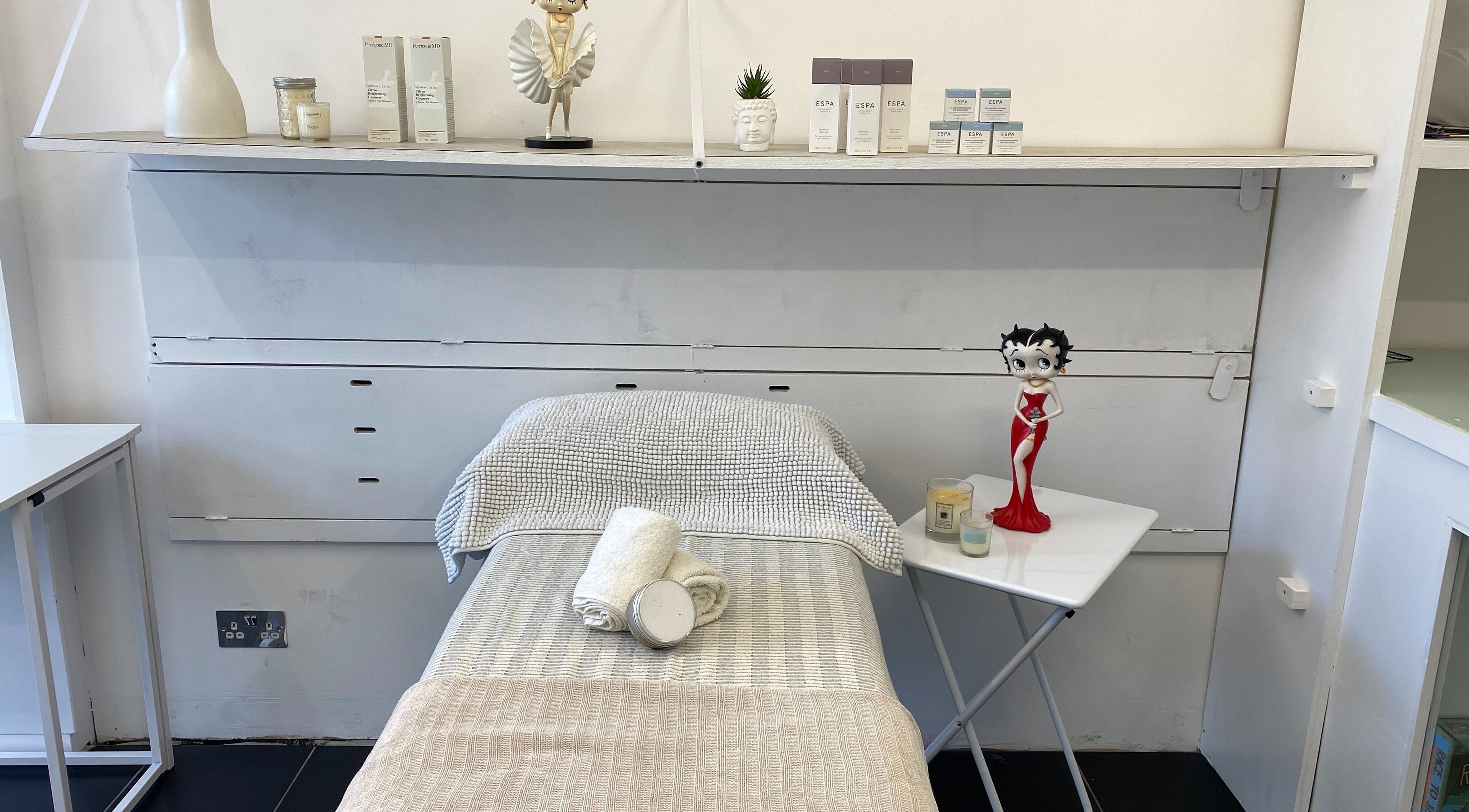 Treatment room at GlamLift, Edinburgh, Scotland, GB with cozy linens and decorative accents.