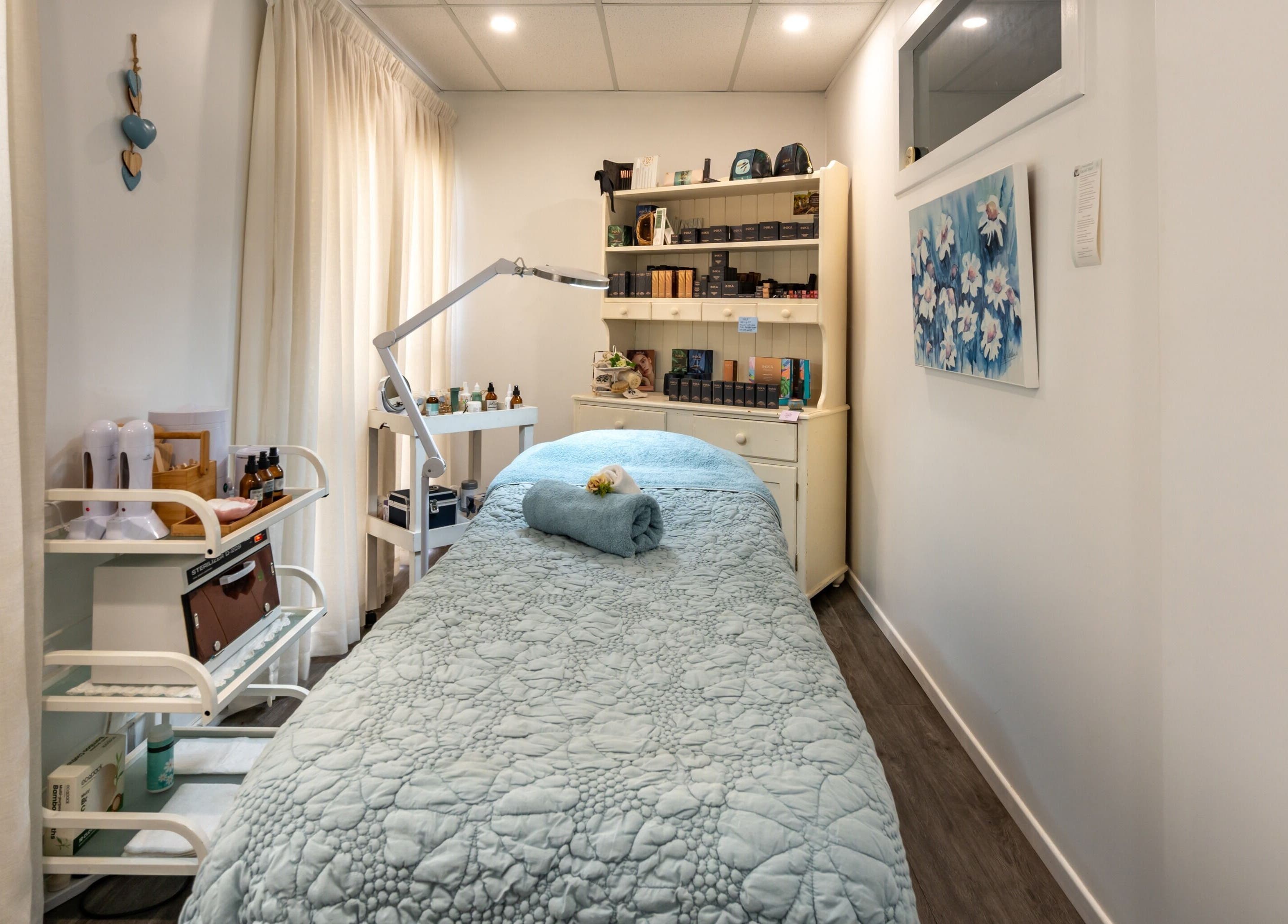 Relaxing massage room at Jodi Lea Natural Beauty, Auckland, Auckland, NZ, with cozy blue bedding and soft lighting.