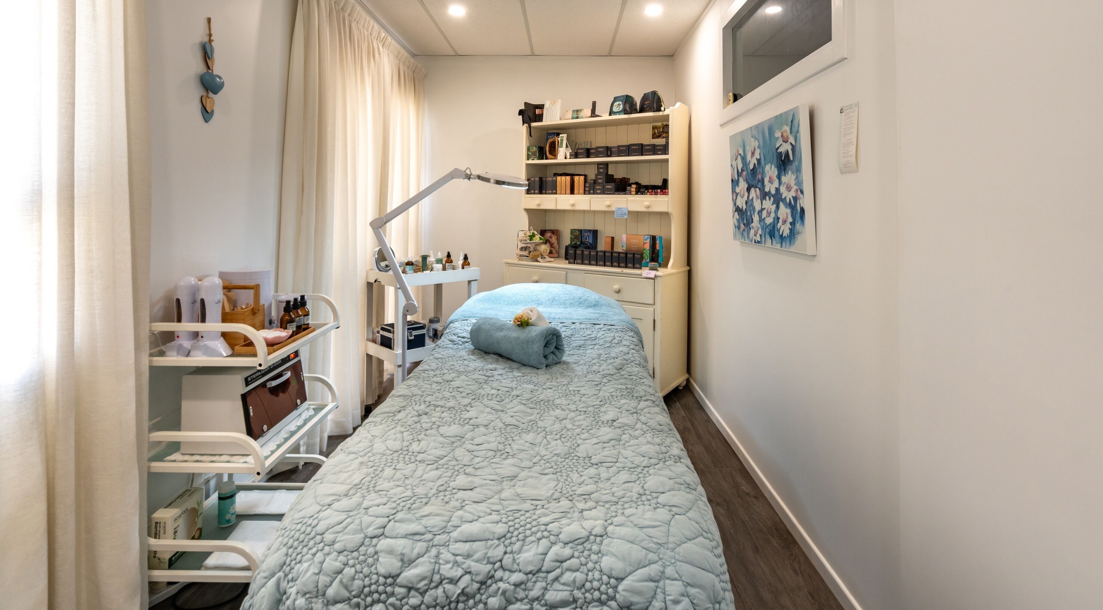 Relaxing massage room at Jodi Lea Natural Beauty, Auckland, Auckland, NZ, with cozy blue bedding and soft lighting.