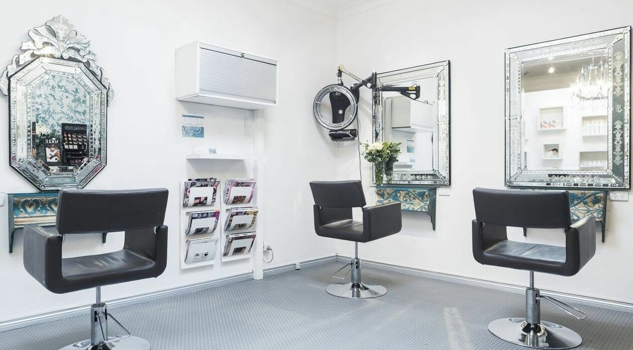 Elegant salon interior at Pixie Hair and Makeup, Coogee, New South Wales, AU, featuring sleek styling chairs and ornate mirrors.