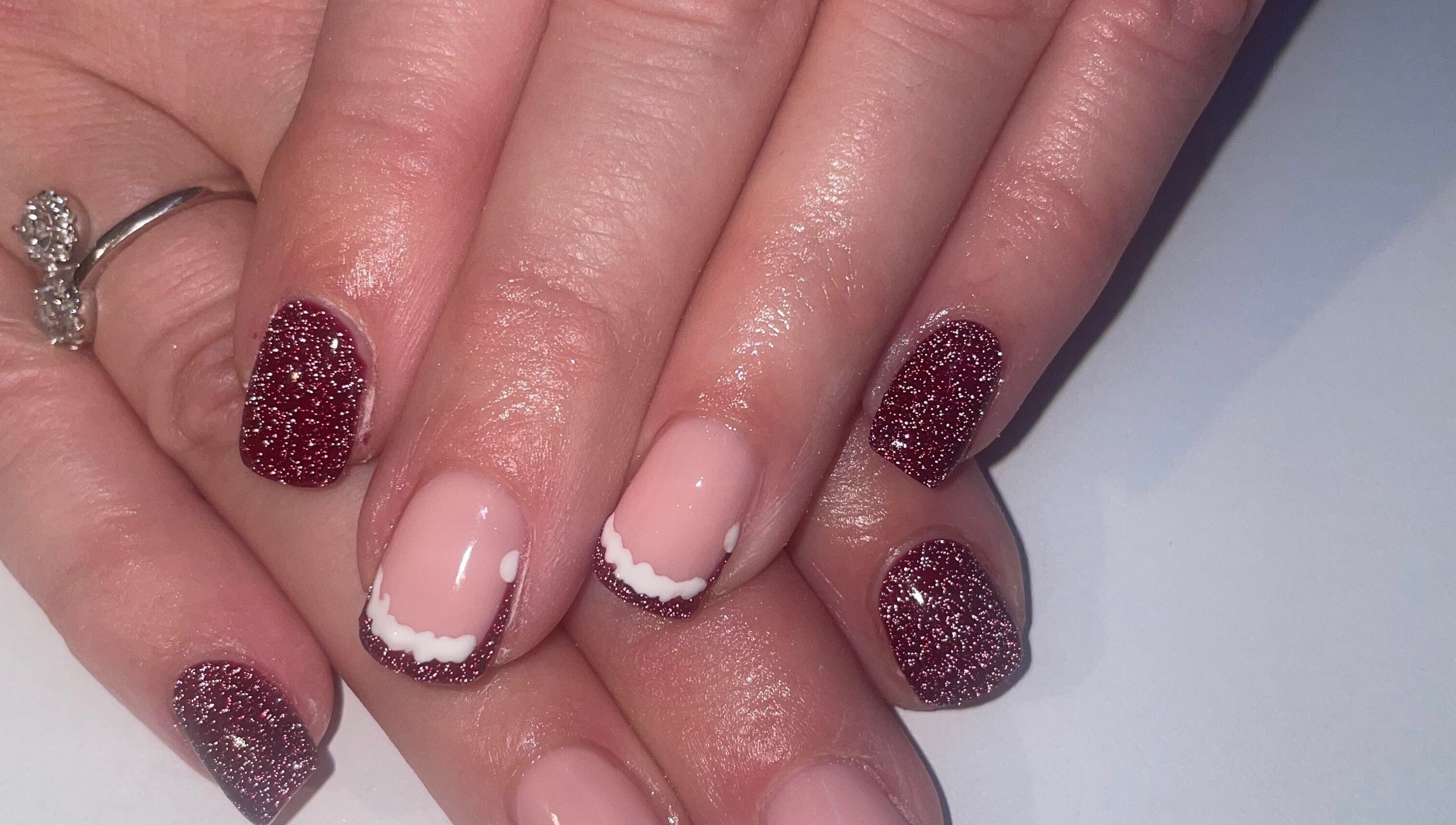 Glittery nail art design at BARE, Port Glasgow, Scotland, GB showcasing elegant ruby sparkle finish.