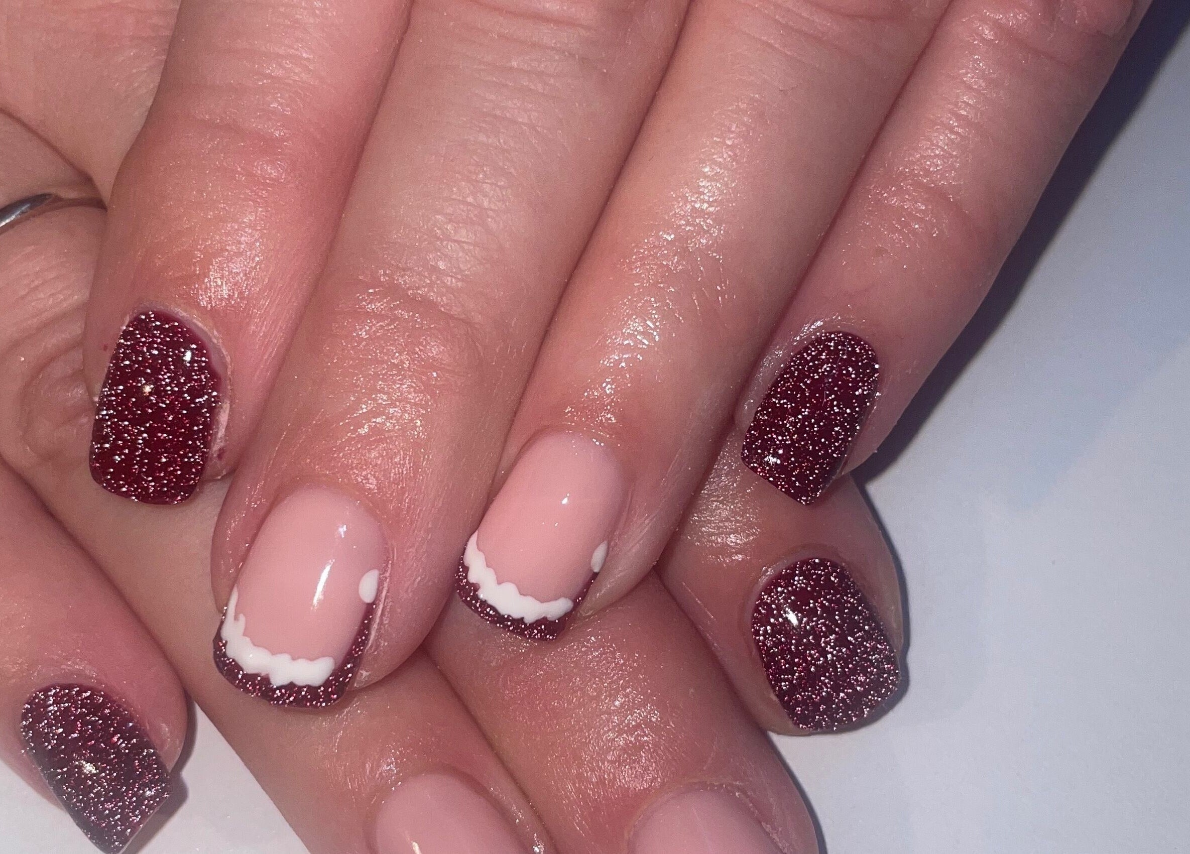 Glittery nail art design at BARE, Port Glasgow, Scotland, GB showcasing elegant ruby sparkle finish.
